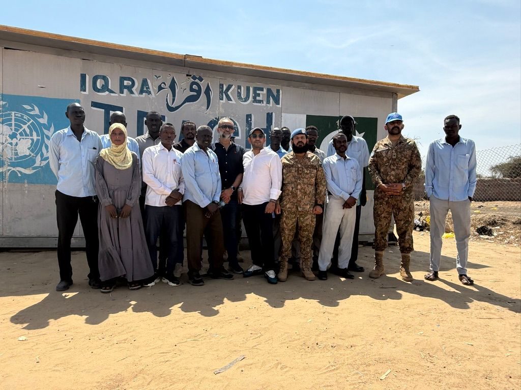Ibrahim AlSafadi during a community engagement visit — the community-impact thread that runs through the Luminus Catering refugee bakery work
